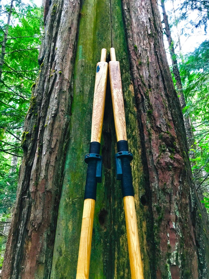 Two rope wrapped custom made wooden oars with square tops and salvaged oak on a solid ash core.
